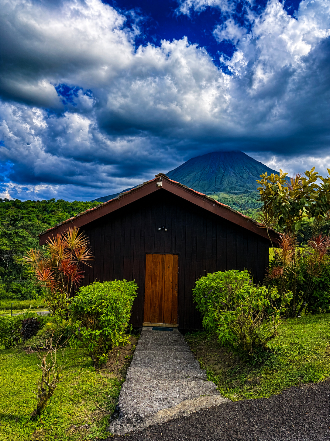 A private bungalow at La Roca Lodge with Arenal Volcano rising behind it.