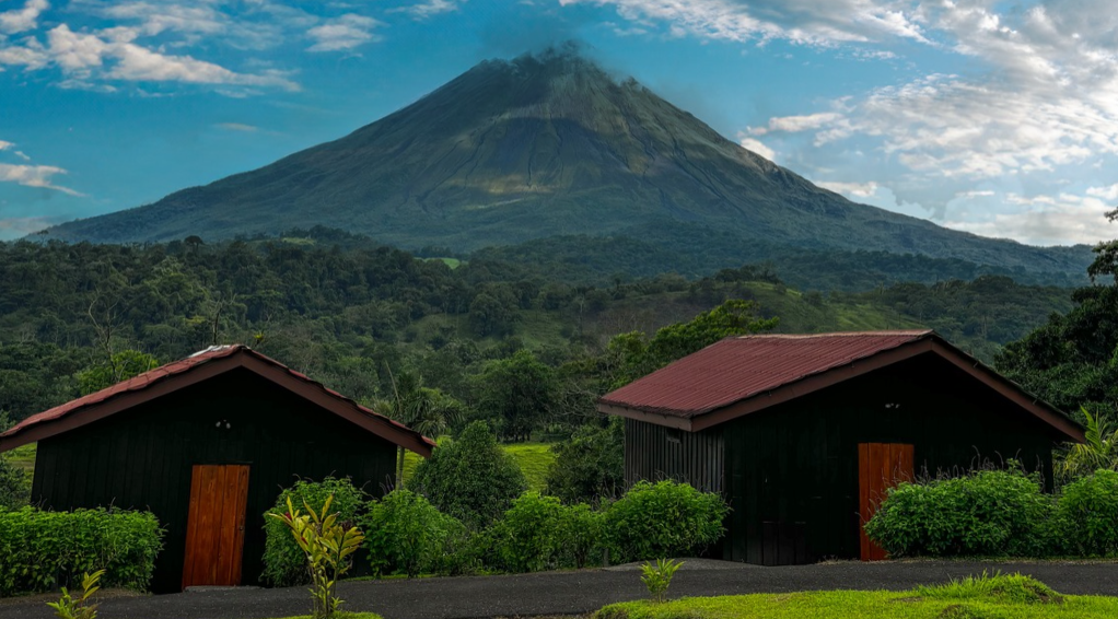 Twin La Roca Lodge bungalows framed by Arenal Volcano.