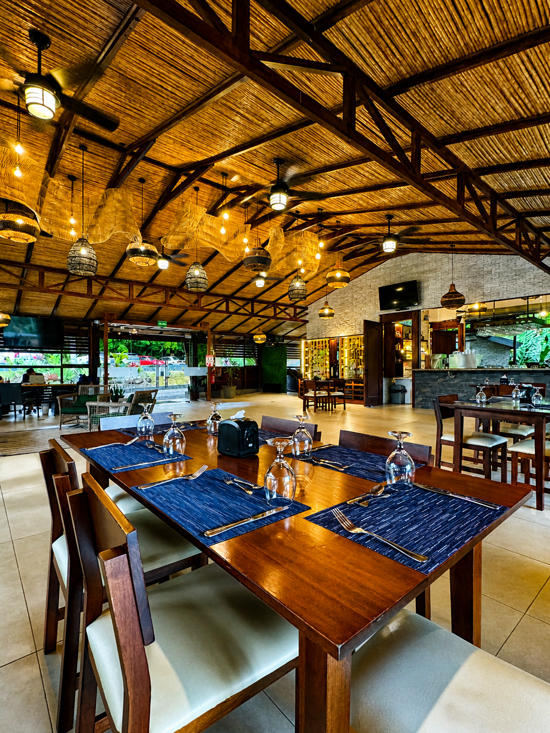 On-site restaurant with thatched roof and pendant lighting.